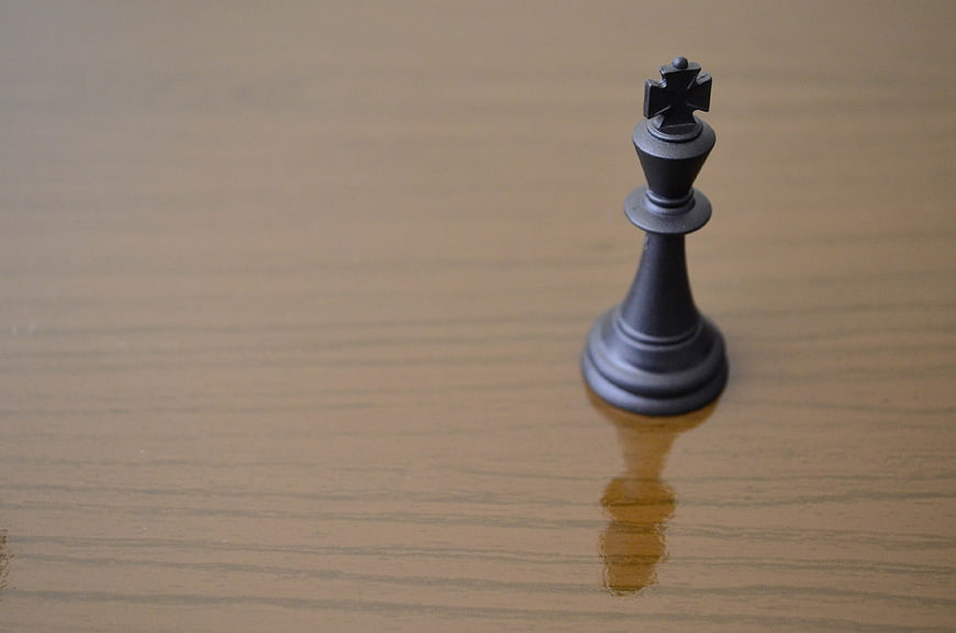 Black Chess King Piece on Wooden Surface