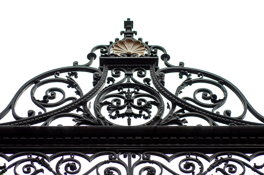 Ornate black wrought iron gate with gold shell detail