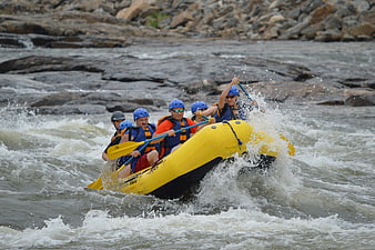 Group of people white water rafting in yellow raft