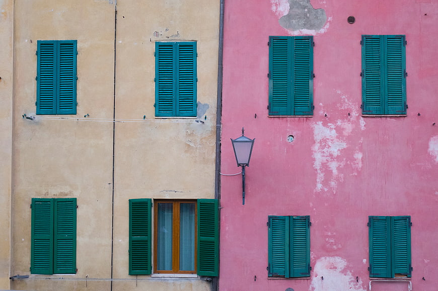 Colorful building facade with green shutters and pink wall