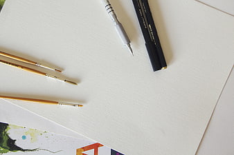 Art supplies on white paper with copyspace