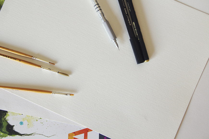 Art supplies on white paper with copyspace
