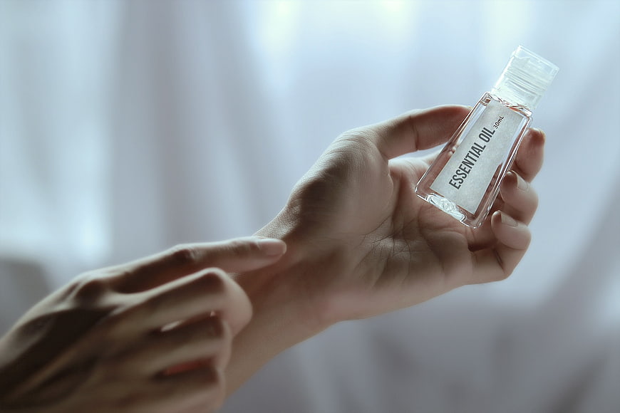 Hand holding essential oil bottle for aromatherapy