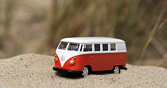 Retro Orange and White VW Camper Van Toy on Sand