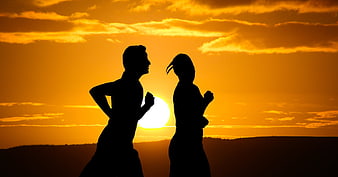 Silhouette of Man and Woman Running at Sunset
