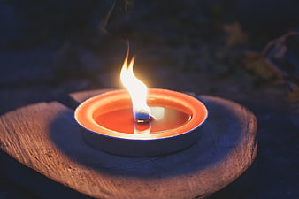 Traditional Diya Oil Lamp Burning on Wooden Base