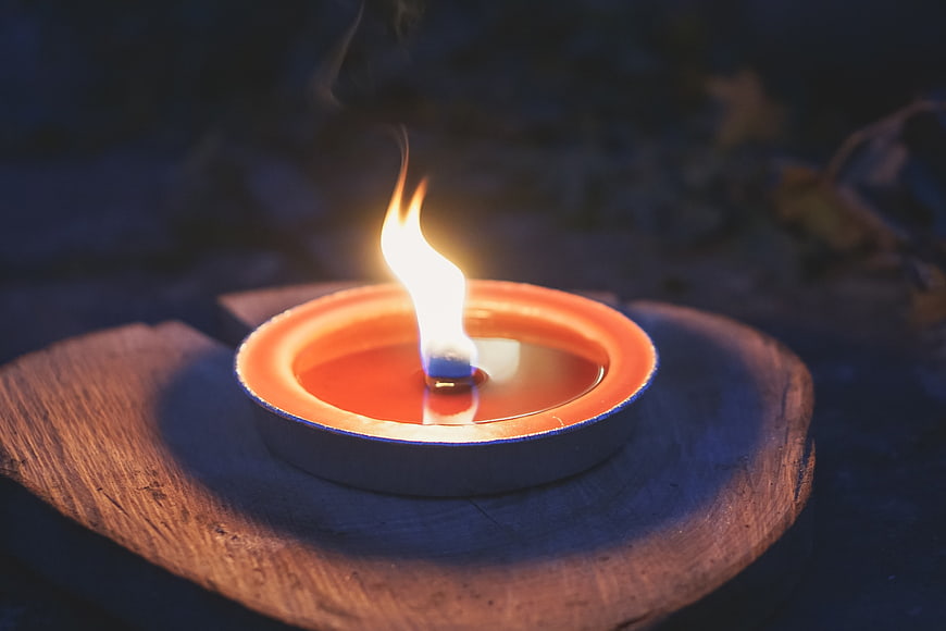 Traditional Diya Oil Lamp Burning on Wooden Base