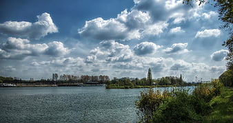 Panoramic river landscape with dramatic clouds and boats