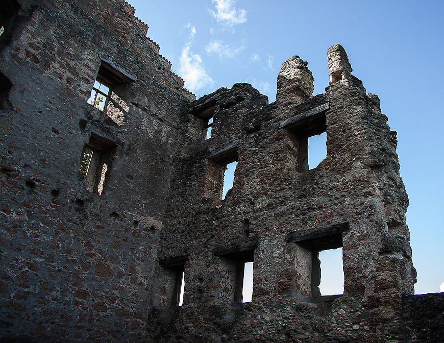 Low angle view of weathered stone castle ruins against blue sky