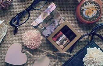 Flat Lay of Lip Gloss Set, Glasses, and Accessories on Burlap