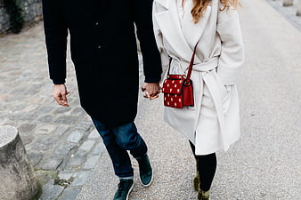 Couple holding hands walking on cobblestone street