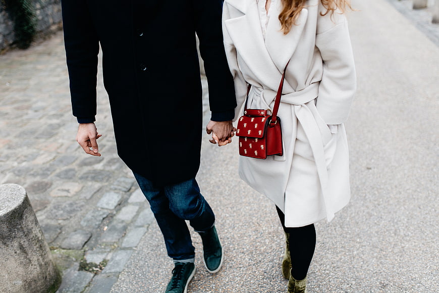 Couple holding hands walking on cobblestone street