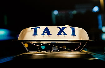 Close-up of Taxi Sign on Car Roof at Night