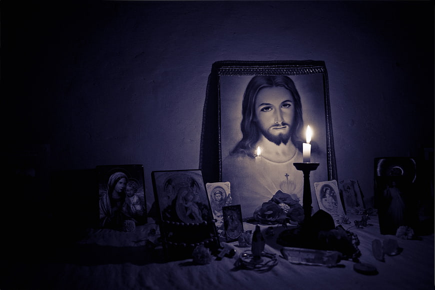 Dark religious altar with Jesus portrait and lit candles
