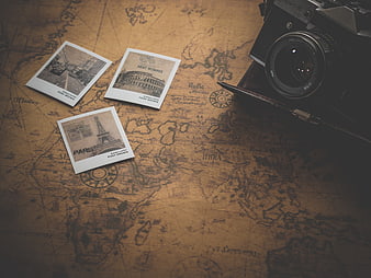 Vintage camera and postcards on old world map background