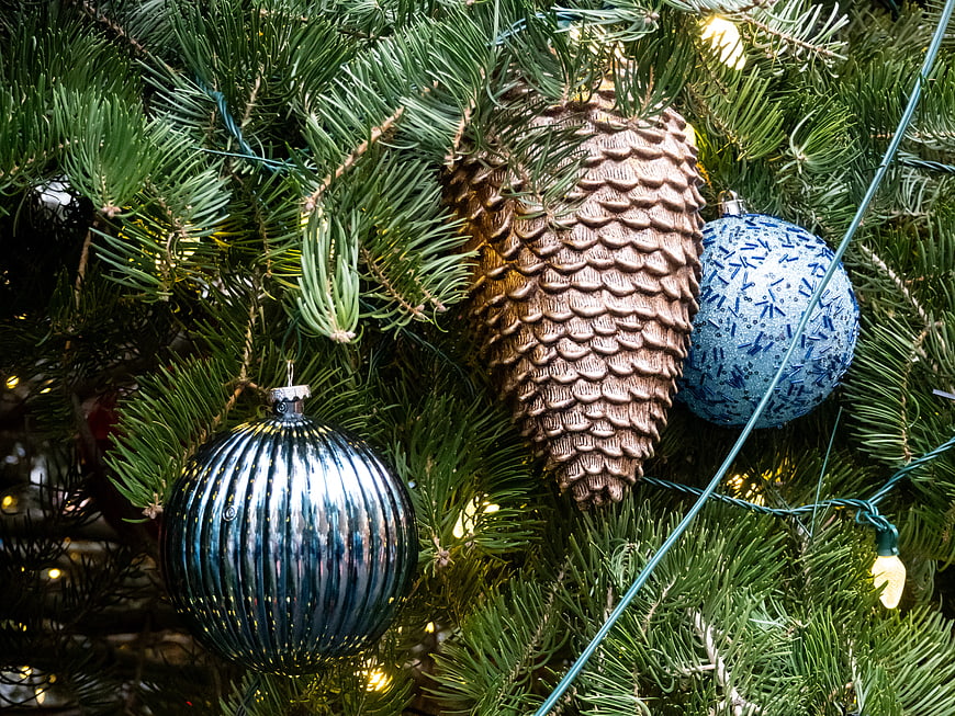Close-up of blue ornaments and pinecone on Christmas tree