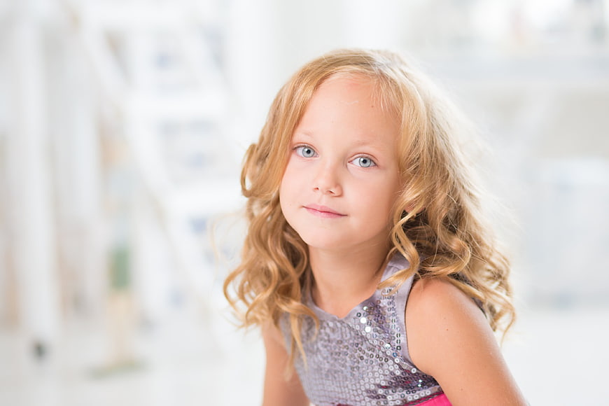 Portrait of a cute little girl with curly blonde hair