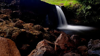 Serene Waterfall Flowing Over Rocks in Lush Forest