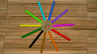Colorful Pencils Arranged in a Circle on Wooden Floor