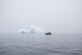 Zodiac boat with tourists near iceberg in Antarctica
