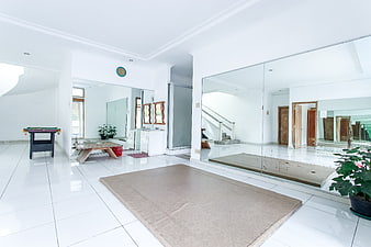 Spacious white living room with yoga mat and pool table