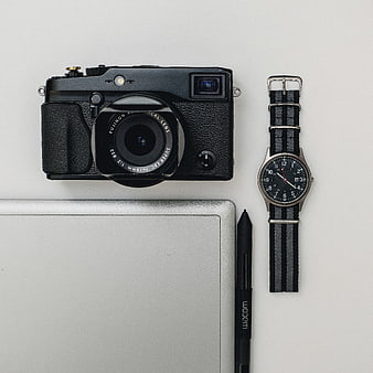 Flat lay of vintage camera, watch, and digital tablet on white background