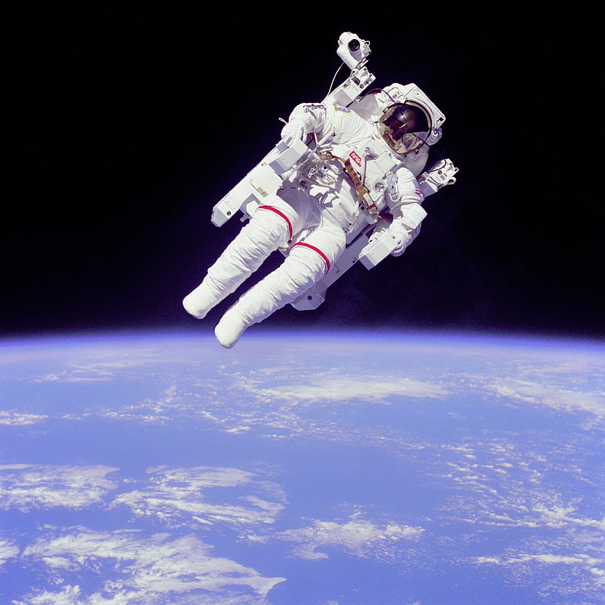 Astronaut floating in space above Earth horizon