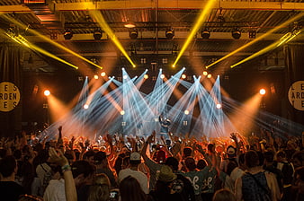 Energetic Crowd at Live Concert with Dramatic Stage Lighting