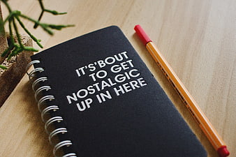 Black Notebook with Nostalgic Quote and Pencil on Desk