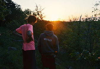 Two Young Men Watching Sunset in Nature