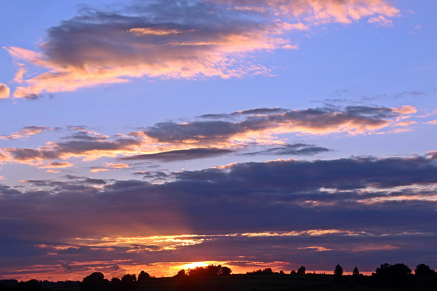 Dramatic Sunset Sky with Pink and Orange Clouds over Silhouette