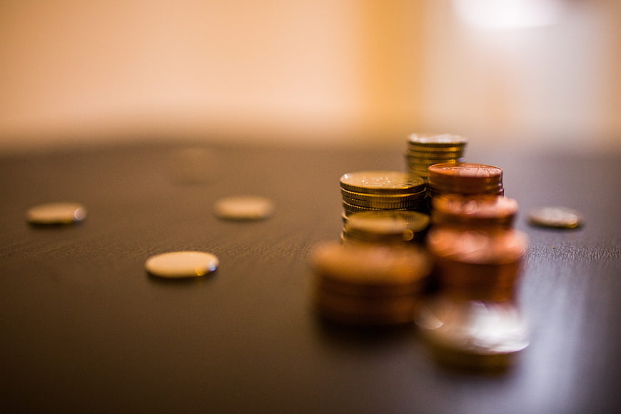 Stacks of coins on dark table with shallow depth of field