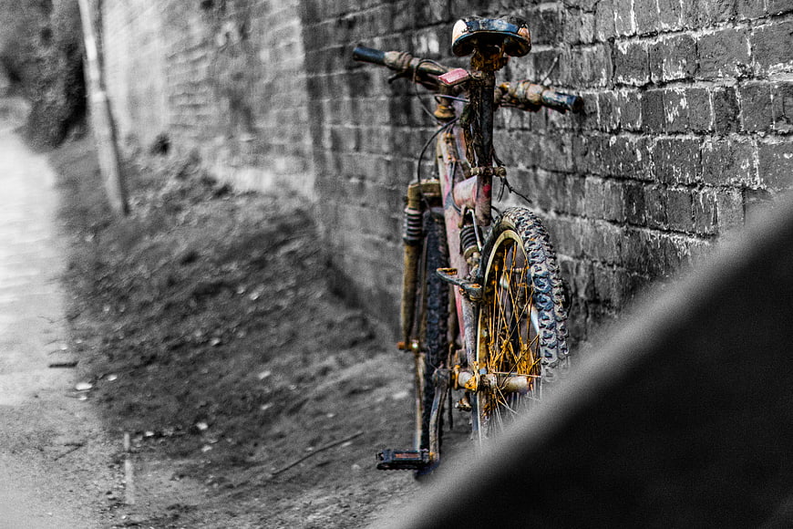 Rusty Mountain Bike Leaning Against Weathered Brick Wall