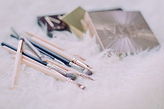 Makeup Brushes and Palette on White Fur Background