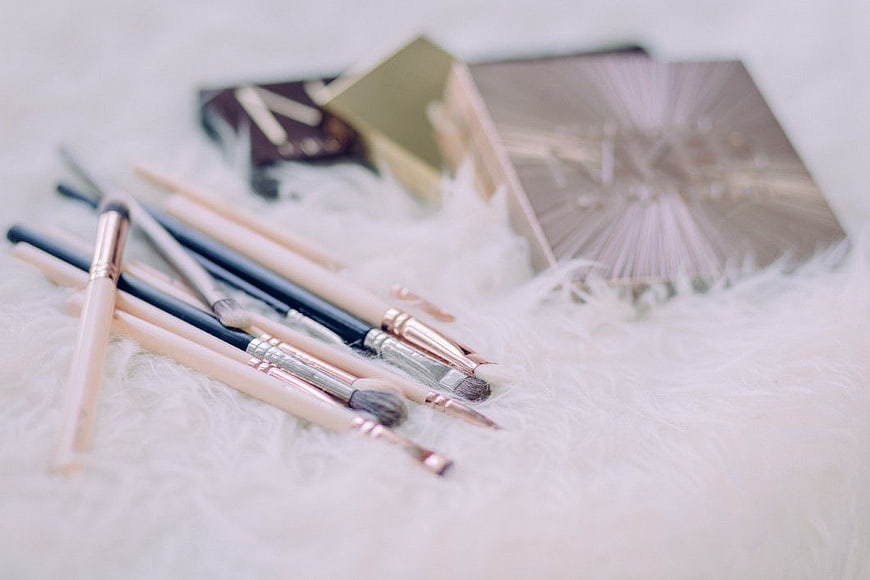 Makeup Brushes and Palette on White Fur Background