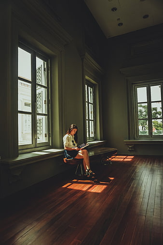 Woman reading magazine in sunlit vintage room