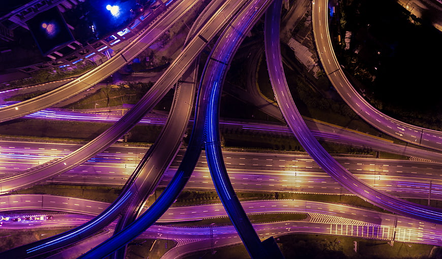 Aerial Night View of Neon Lit Highway Interchange