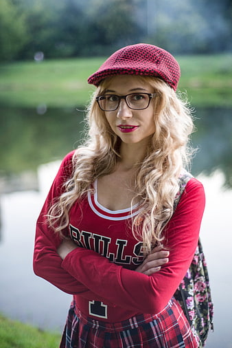 Young woman in red Bulls jersey and plaid skirt outdoors