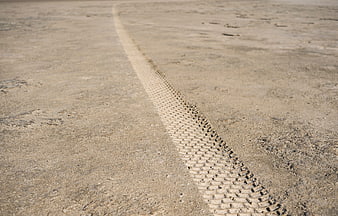 Close-up of tire track in dry sandy soil
