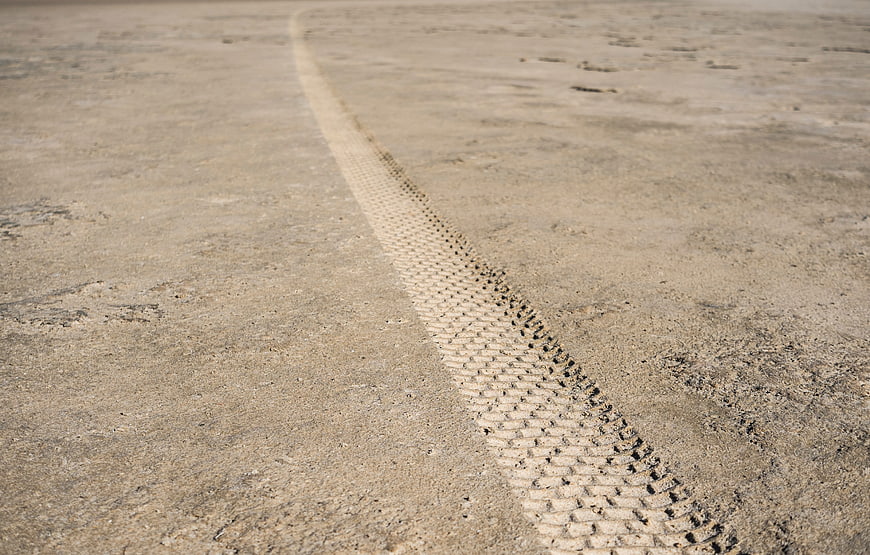 Close-up of tire track in dry sandy soil