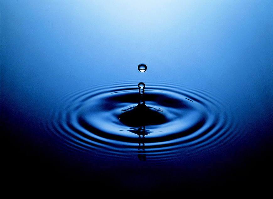 Blue Water Drop Splash with Ripples on Dark Background