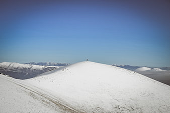 Snowy Mountain Peak with Summit Marker and Blue Sky