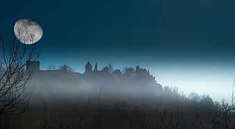 Misty Castle Silhouette at Dawn with Large Moon