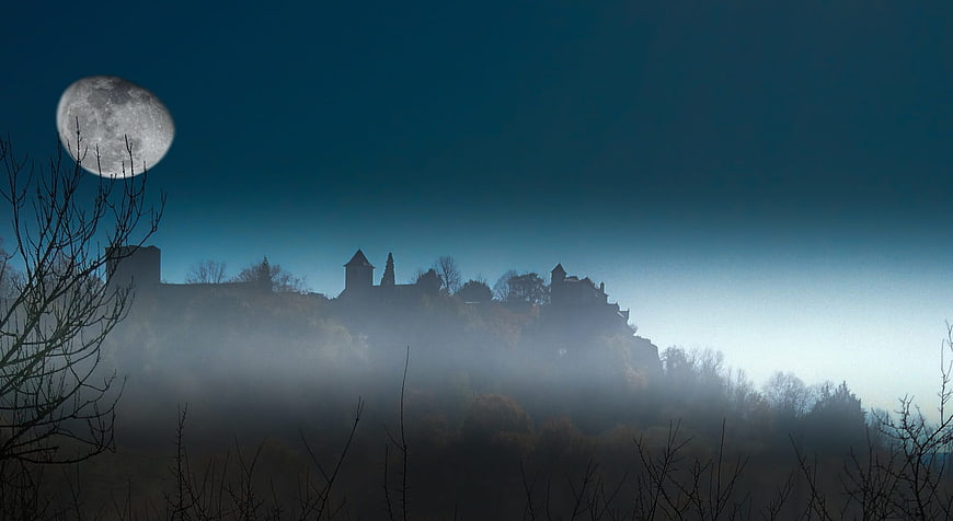 Misty Castle Silhouette at Dawn with Large Moon