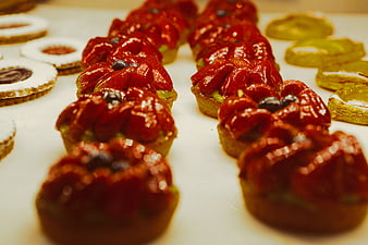 Glossy Strawberry Tarts with Blueberries on White Surface