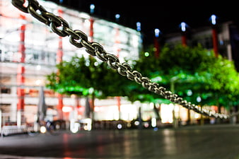Metal chain barrier with blurred city lights at night