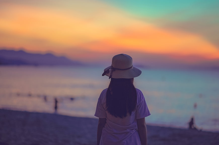 Woman in Hat Watching Sunset Over Ocean