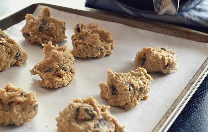 Raw chocolate chip cookie dough balls on baking sheet