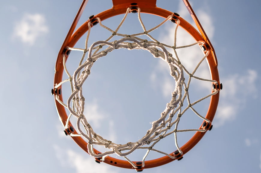 Low angle view of orange basketball hoop against blue sky