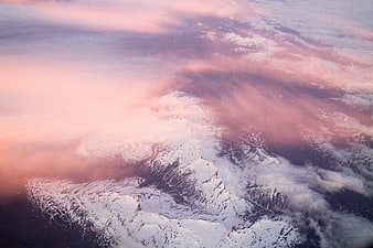 Aerial View of Snowy Mountains with Pink Clouds